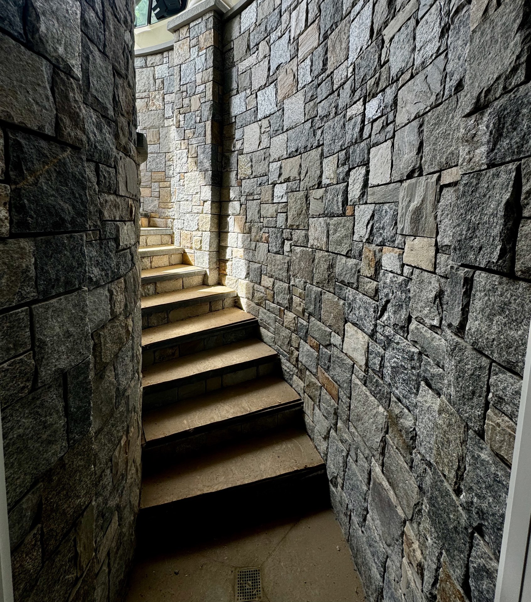 Curved granite stairwell built by Foxpoint, lit by natural sunlight